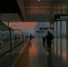 people are waiting at the train station for their trains to arrive in the evening time