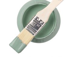 a paint brush sitting on top of a green bowl