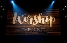 worship the king stage set with spotlights and wooden sign on it's side