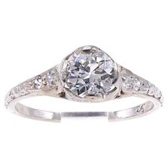 an antique style diamond ring with diamonds on the sides and shoulders, set in white gold