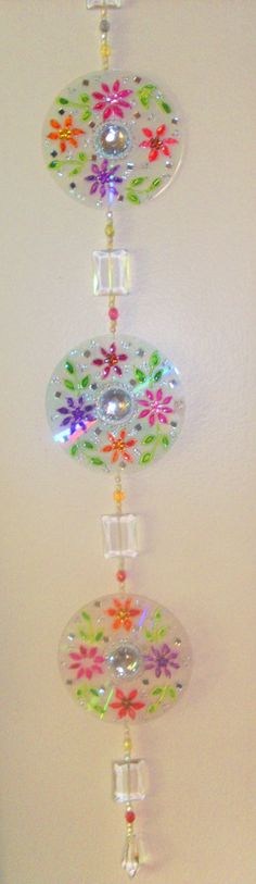 a multicolored glass wind chime hanging from the ceiling in a room with white walls