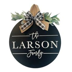 a black and white sign with a bow on it that says the lanson family