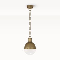 an antique brass finish pendant light with a white glass ball hanging from the bottom and chain