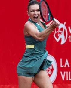 a female tennis player is holding her racquet up to hit the ball with her mouth wide open