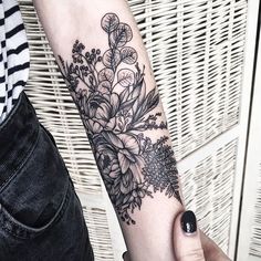 a woman's arm with a flower tattoo on it