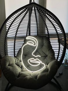 a hanging chair with a neon sign in the shape of a woman's face