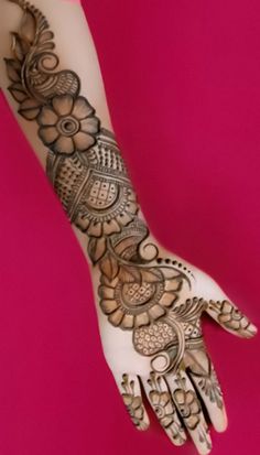 a woman's hand with henna tattoos on it