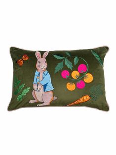 a green pillow with an image of a rabbit and carrots on the front side