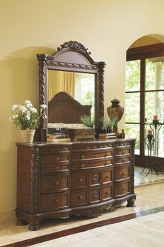 a bedroom with a dresser and mirror in it