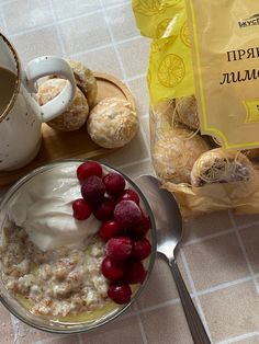 a bowl of oatmeal with raspberries next to a bag of muffins