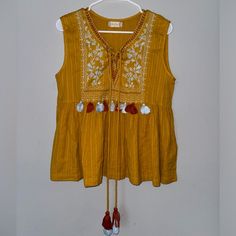 Embroidered Altar’d State Mustard Yellow Tank Top With Tassels. Bohemian Chic Look. Very Cute Detailing And Stylish For Spring And Summer! Never Worn, Like New Material. Size Medium And True To Size. In Perfect Condition! Spring Cotton Embroidered Top With Tassels, Festival Cotton Blouse With Tassels, Cotton Festival Blouse With Tassels, Yellow Bohemian Tops For Festive Occasions, Cotton Tassel Tops For Festivals, Festive Bohemian Yellow Tops, Bohemian Sleeveless Top With Tassel Ties, Sleeveless Tops With Tassel Ties For Spring, Yellow Tank