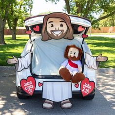 a man in jesus's love car with a teddy bear sitting on the back