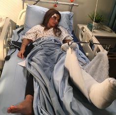 a woman laying in a hospital bed with an iv drip attached to her arm and leg