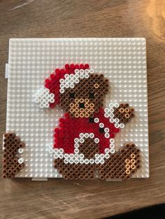 a small beaded christmas ornament with a teddy bear on it