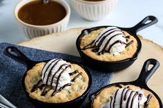 chocolate chip skillet cookies in cast iron pans with whipped cream drizzled on top