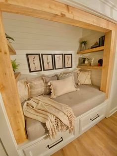 a bed that is in the middle of a room with some pillows and blankets on it