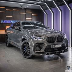 a silver bmw suv parked in front of a purple wall