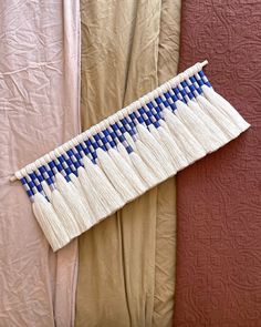 a piece of cloth with blue and white designs on it sitting next to some curtains