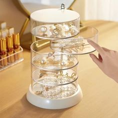 there is a jewelry rack on the table with pearls and other items in it,