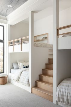 a bedroom with bunk beds and stairs leading up to the second floor bed in front of a window