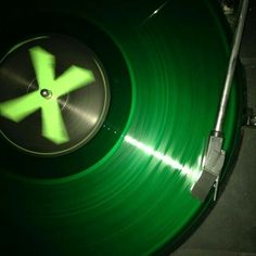 a green record player with the letter k on it's side and a black background