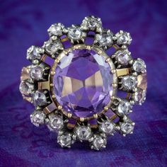 A remarkable Georgian cluster ring adorned with a regal oval cut amethyst in the centre with a soft violet hue. It weighs approx. 4.5ct and is framed by a double ring of twinkling old rose cut diamonds, totalling approx. 0.85ct.  Amethyst is the birthstone of February and is considered a stone of protection, clarity and tranquillity. Its deep violet colouring has been highly esteemed throughout history, adorning regal jewellery all around the world, from ancient Egypt to the British crown jewels Antique Oval Purple Amethyst Ring, Antique Oval Amethyst Ring, Elegant Cluster Amethyst Ring, Oval Purple Amethyst Ring With 17 Jewels, Elegant Amethyst Cluster Ring, Elegant Purple Cluster Amethyst Ring, Purple Cluster Rings For Formal Occasions, Formal Purple Cluster Rings, Victorian Style Oval Purple Amethyst Ring