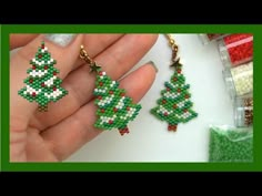 a hand holding two christmas trees made out of seed beads and bead threads