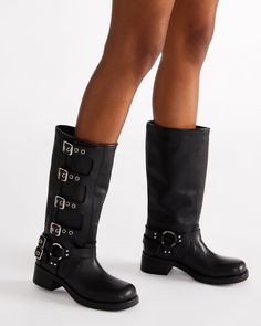 The ROCKY knee boot features the wide profile of an engineer boot with harness and buckle hardware adding an industrial edge and giving the design an adjustable fit. Block heel engineer boot Slip-on style Top gore with 4 adjustable buckle straps 2 inch heel height Size 6 measurements: 14.5 inch shaft circumference, 12.5 inch shaft height Size 8 measurements: 15 inch shaft circumference, 13 inch shaft height Size 10 measurements: 16 inch shaft circumference, 13.5 inch shaft height Leather upper m Edgy Knee-high Moto Boots With Buckle, Edgy Knee-high Moto Boots With Buckle Closure, Edgy Knee-high Boots With Buckle Closure, Punk Style Leather Knee-high Boots With Buckle, Edgy Leather Knee-high Boots With Buckle Closure, Punk Boots With Buckle Closure For Biker Events, Platform Slip Ons, Summer Wardrobe Staples, Engineer Boots