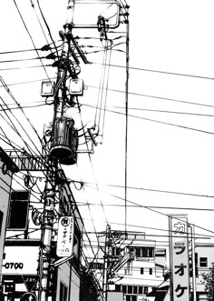 black and white photograph of power lines in an urban area with buildings on either side