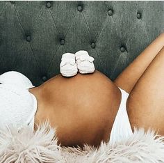 a woman laying on top of a couch wearing white shoes