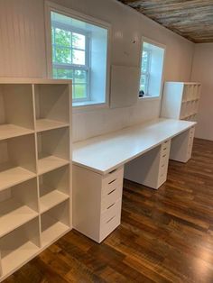 an empty room with white shelving and wooden floors