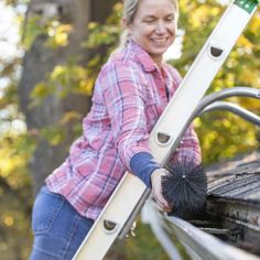 a woman is smiling while holding onto a ladder