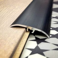 a black and white pattern on the floor next to a wooden door frame with an edge cut out