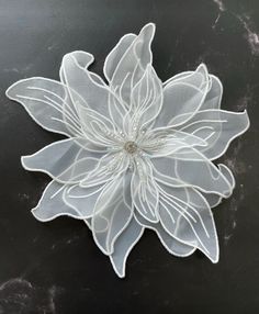 a white flower on a black surface