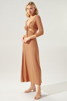 The Neada family is expanding with a new maxi dress. Made from the same soft and stretchy, Hatchi knit, it shapes a beautiful three quarter sleeve dress with side cut outs and an adjustable front tie at the chest. Pulled tight, it creates a ruched, sweetheart neckline with a subtle A line silhouette skirt. It's a great transition dress that can be worn with mules, sandals, or even chelsea boots.- Stretchy - Elastic casing- Adjustable drawstring- Cut outs- Color: BiscuitSize + Fit - Model is 5'8" Brown Stretch Maxi Dress, Spring Stretch Brown Maxi Dress, Spring Brown Stretch Maxi Dress, Fitted Ribbed Dress For Vacation, Brown Ribbed Spring Dress, Stretch Maxi Dress For Beach In Fall, Ribbed Midi Dress For Vacation, Fall Ruched Maxi Dress For Day Out, Spring Ribbed Maxi Dress