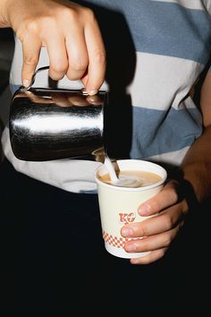 a person is pouring something into a cup