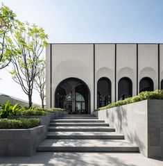 the entrance to an office building with concrete steps and planters on either side of it