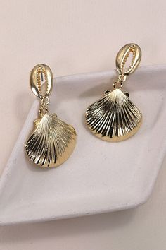 Gold Puka Seashell Drop Earrings, a stunning accessory that embodies coastal elegance. These earrings feature delicately crafted gold puka seashells, creating a chic and timeless design that seamlessly complements a variety of looks. Perfect for adding a touch of seaside allure to your ensemble, the Gold Puka Seashell Drop Earrings are versatile enough for both casual outings and more formal occasions.Product details:length: 1.5"width: 1" earring back: Postmetal finish: gold Platingproduct: Lead Gold Teardrop Earrings For The Beach, Gold Shell Dangle Earrings, Gold Teardrop Jewelry For The Beach, Gold Teardrop Jewelry For Beach, Gold Dangle Earrings For Beach, Ocean-inspired Gold Shell-shaped Jewelry, Gold Shell-shaped Metal Earrings, Gold Dangle Shell Earrings For Beach, Gold Plated Shell-shaped Earrings