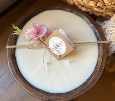 a candle with a tag tied to it sitting on a table next to some twine