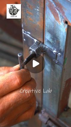 a man is working on a metal object with a screwdriver in his hand