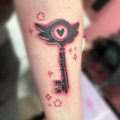 a key tattoo on the arm with stars around it and a heart at the top