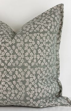 a gray and white pillow with small flowers on it