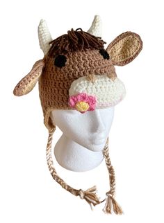 a crocheted cow hat on top of a white mannequin head