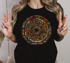 a woman wearing a black t - shirt with a colorful design on the front and back