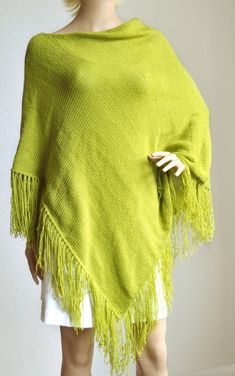 Pistachio green women's poncho handmade from soft and light wool yarn. Warm and cosy with also handmade fringes. This long poncho will warm you up in chilly evening. Edge facings accurately decorated by hand with crochet hook. Accurately knitted from high quality yarns, so, poncho is durable and easy to maintain. Size: universal, length 32'' (81cm), width 32'' (81cm). Fiber: wool - acrylic yarns. Care: hand wash at 30 degrees C. - lay flat to dry. Green One-size Winter Poncho, Green One Size Winter Poncho, Green Shawl Poncho For Fall, Green Shawl Poncho One Size, Green One-size Shawl Poncho, Oversized Green Poncho For Winter, Cozy One-size Green Poncho, Long Poncho, Womens Poncho