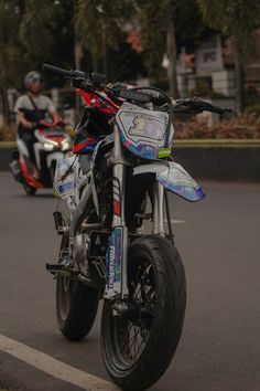 a motorcycle parked on the side of the road next to another motorcyclist