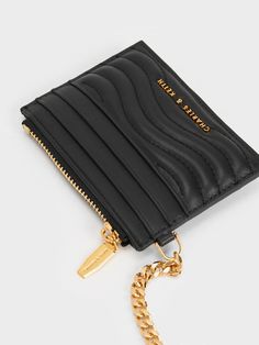 This product is made with at least 20% sustainable materials by weight. CHARLES & KEITH uses recycled, degradable, organic, and water-based materials in our eco-conscious collection. Nothing like a sleek black accessory to introduce a hint of sophisticated elegance to your looks. With our Aubrielle card holder in tow, you can leave your bulky wallet behind. Tactile to the touch and visually captivating thanks to the stitch-trim details and gold-tone hardware, it is a charming addition to any accessory arsenal. Keep your cards and curios secure, safe and sound by storing it in this gem. Complete with a detachable chain clip, it will let you go hands-free with effortless style. Safe And Sound, Let You Go, Black Accessories, Charles Keith, Trim Detail, Eco Conscious, Sustainable Materials, Kids Gifts, Hands Free