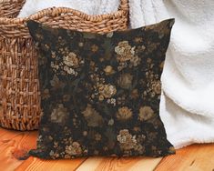 a black pillow sitting on top of a wooden floor next to a basket and blanket