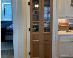 an open door leading into a kitchen with white cabinets and counter tops in the background