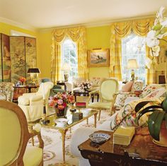 a living room filled with lots of furniture and flowers in vases on the table